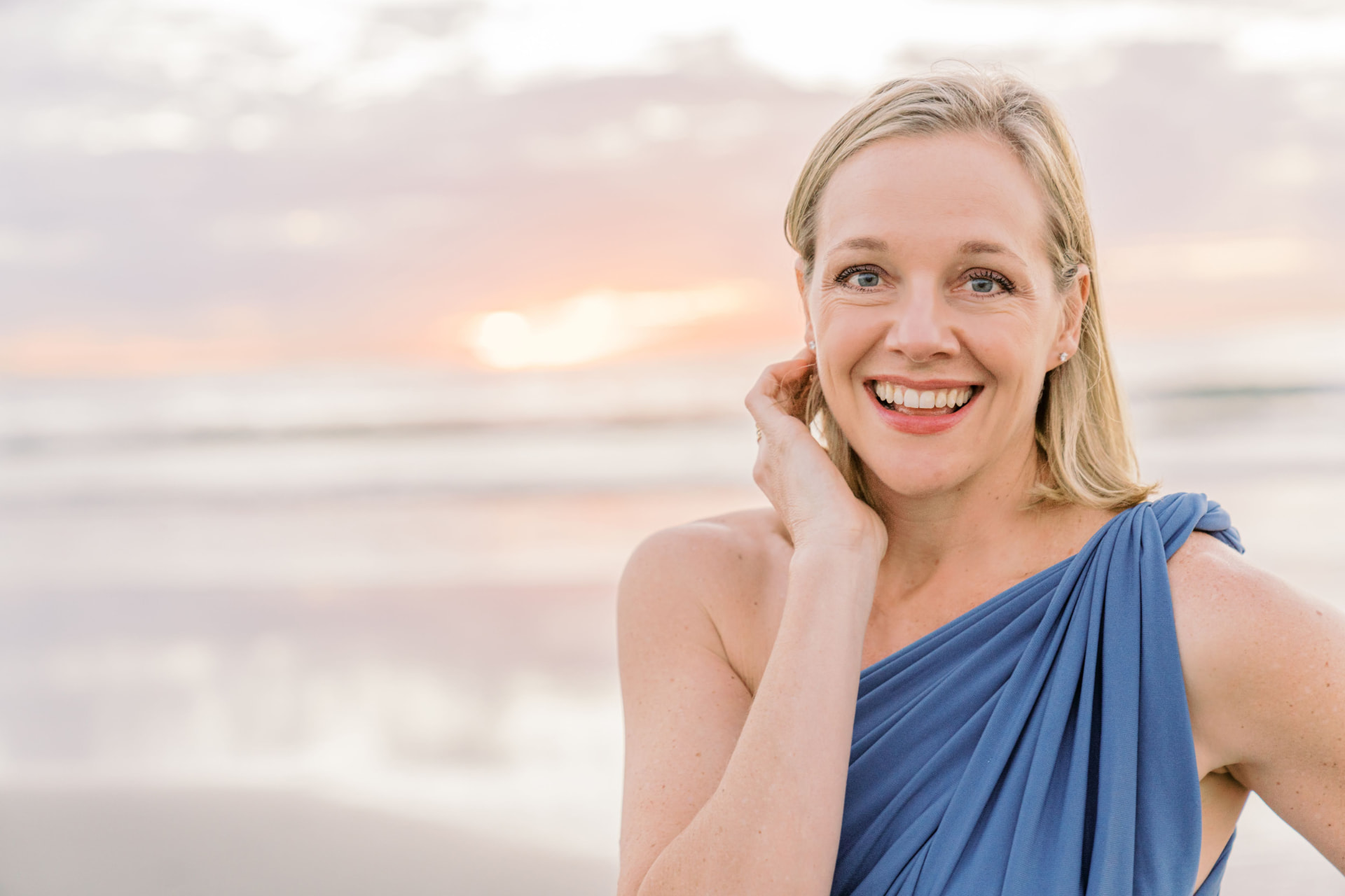 Susan Sjolund smiling on the beach at sunset
